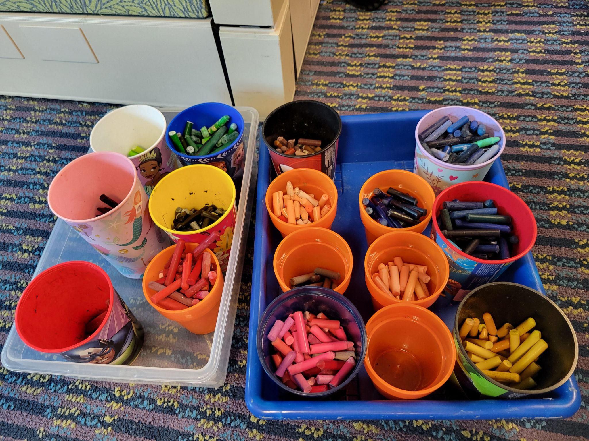 Cups of broken crayons, sorted by color