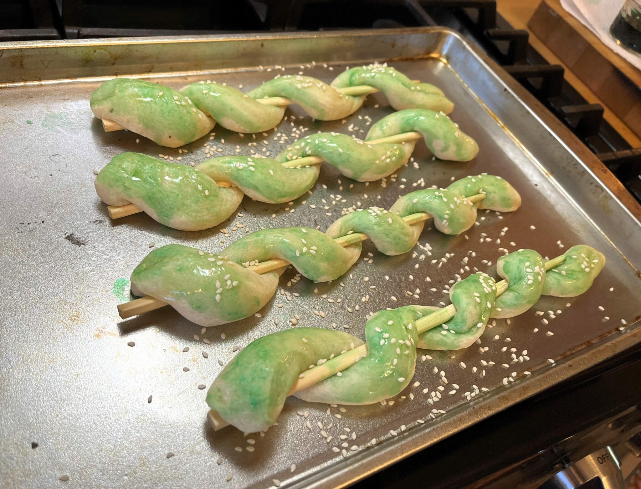 Snake breadsticks with green food coloring and sesame seeds