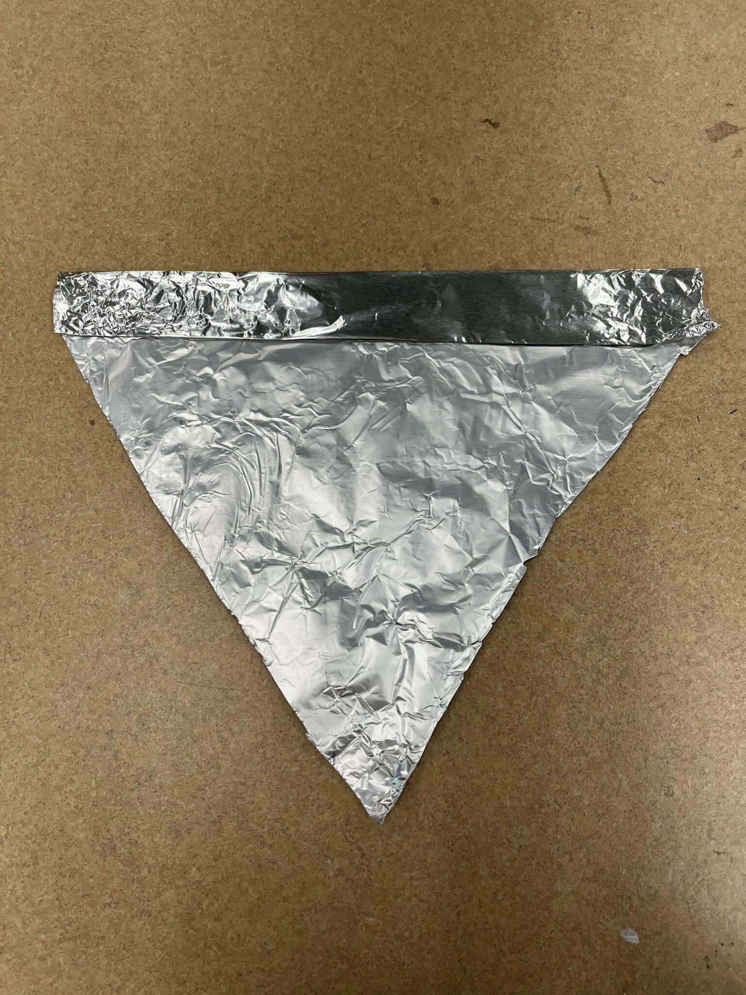 Square of aluminum foil with top folded