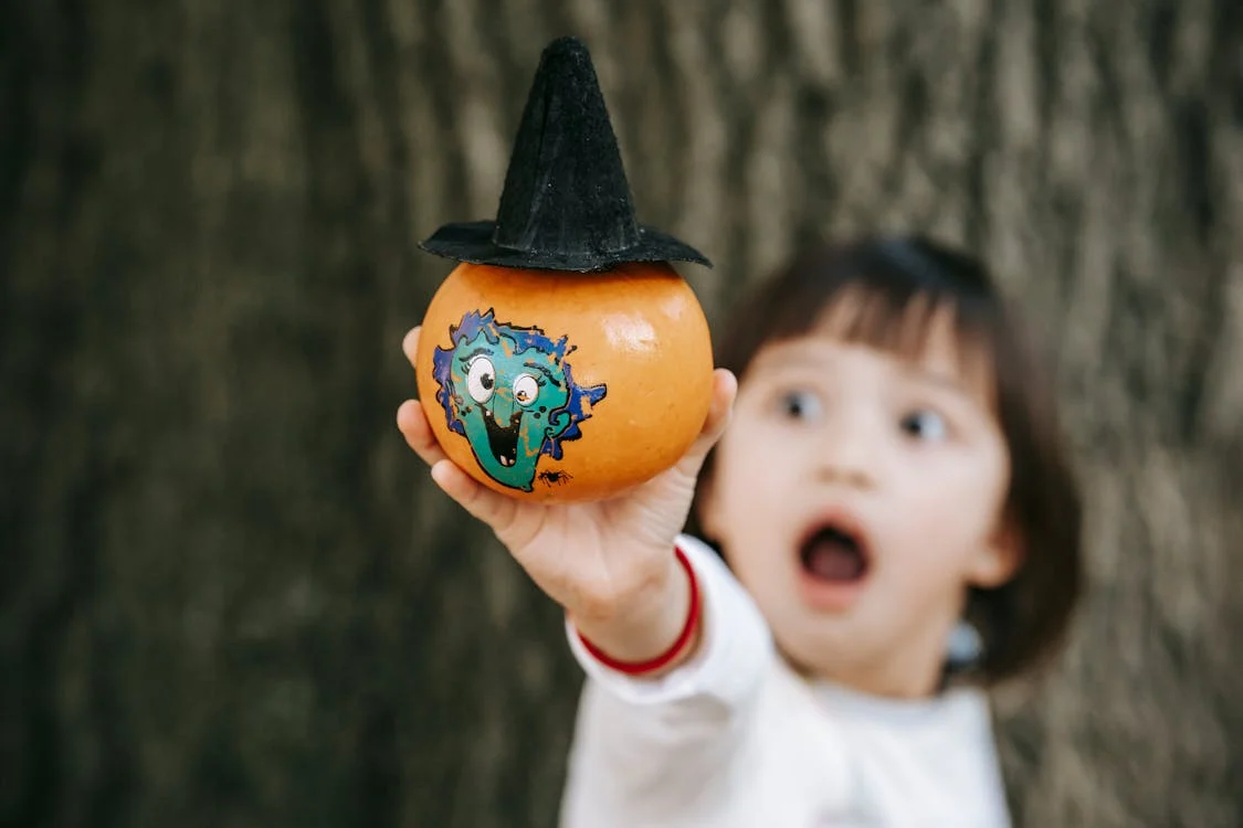 Image of child holding painted pumpkin