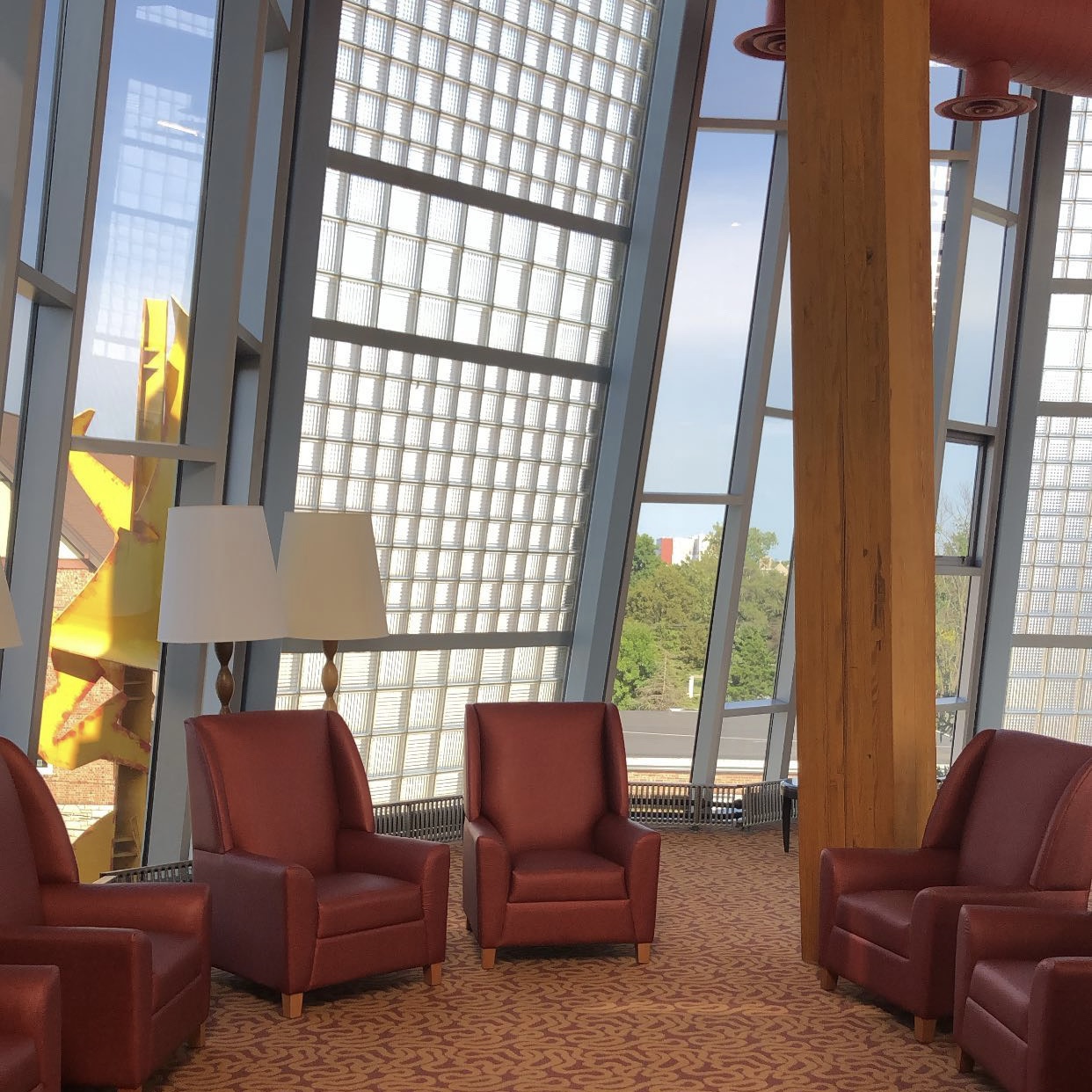 photo of plush chairs arranged in a circle in a room made of windows